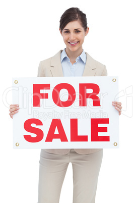 Smiling businesswoman with for sale sign