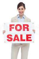 Smiling businesswoman with for sale sign