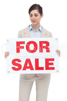 Estate agent holding for sale sign