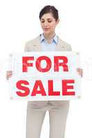 Estate agent holding for sale sign