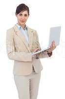 Serious young businesswoman holding laptop