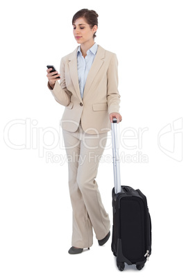 Businesswoman with suitcase and phone