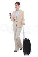 Businesswoman with suitcase and phone