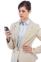 Serious businesswoman posing with phone on right hand