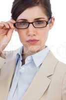 Serious businesswoman holding her glasses