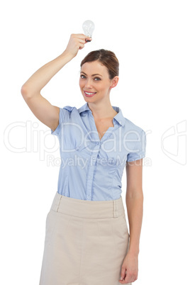 Businesswoman holding a light bulb above her head
