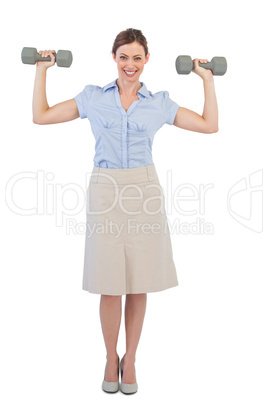 Strong businesswoman posing with dumbbells