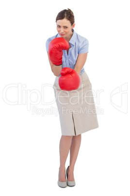 Attractive businesswoman posing with red boxing gloves