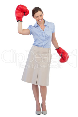 Happy businesswoman posing with red boxing gloves