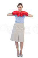Tough businesswoman posing with red boxing gloves