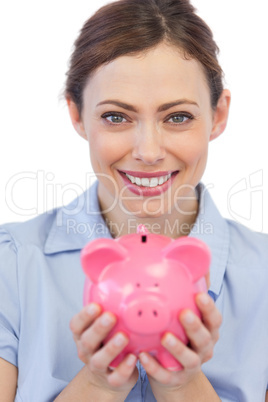 Businesswoman showing her piggy bank to camera