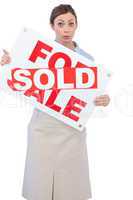 Estate agent showing for sale sign with sold sticker across it