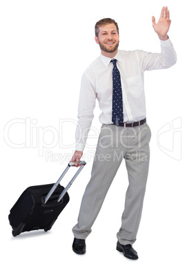 Handsome businessman with suitcase waving