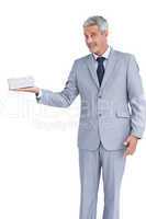 Handsome businessman holding gift and looking at camera