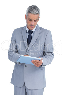 Frowning businessman using tablet pc Frowning businessman using tablet pc