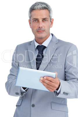 Serious businessman using digital tablet