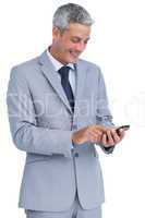 Cheerful businessman sending text message