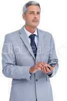 Thoughtful businessman sending text message