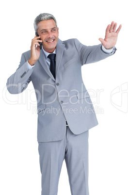 Businessman answering phone and waving