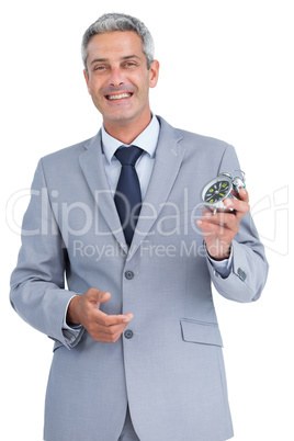 Cheerful businessman holding alarm clock