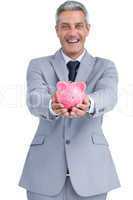 Wide smiling businessman holding piggy bank