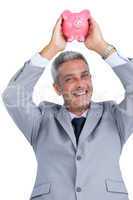 Cheerful businessman holding piggy bank above his head
