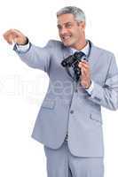 Businessman holding binoculars and pointing out something