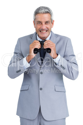 Cheerful businessman observing with binoculars