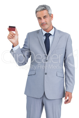 Handsome businessman showing credit card