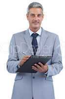 Businessman holding clipboard and taking notes