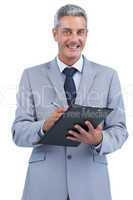 Joyful businessman holding clipboard and taking notes