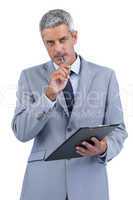 Assiduous businessman holding clipboard and taking notes