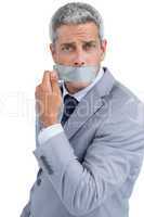 Businessman taking off duct tape on mouth