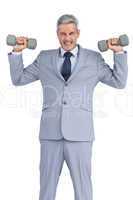 Strong businessman lifting dumbbells