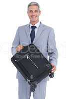 Smiling handsome businessman carrying suitcase