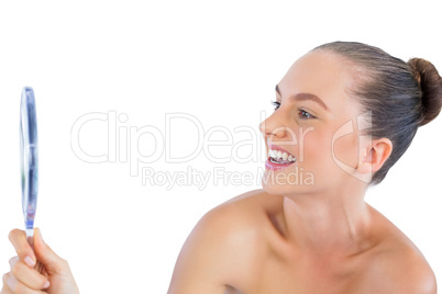Smiling young woman holding mirror
