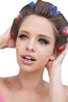 Model with hair curlers touching her hair
