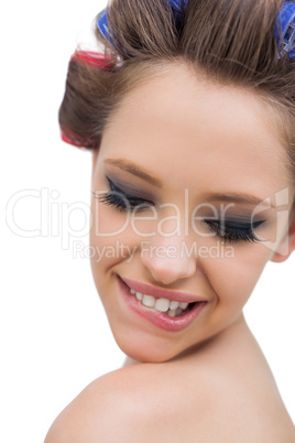 Model wearing hair curlers smiling in close up