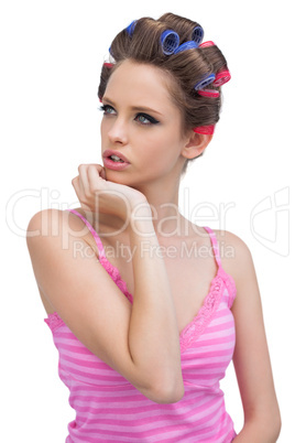 Thoughtful model in hair curlers posing and looking away
