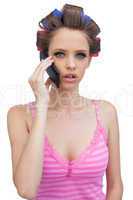 Young lady in hair curlers having a phone call