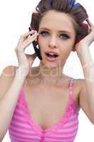 Sexy young model wearing hair rollers with phone