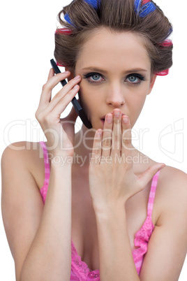 Secretive model wearing hair rollers with phone