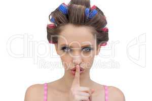 Model in hair rollers posing with finger on mouth