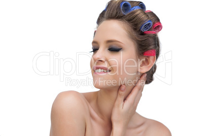 Sensual young model in hair rollers closing eyes