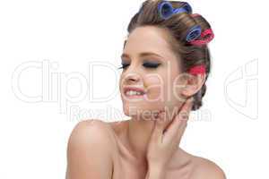 Sensual young model in hair rollers closing eyes