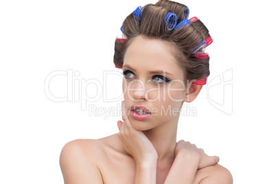 Seductive lady in hair rollers posing and looking away