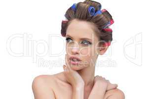 Seductive lady in hair rollers posing and looking away