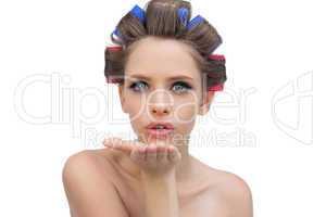 Young model in hair rollers blowing a kiss