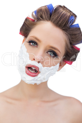 Model in hair curlers with shaving foam in close up