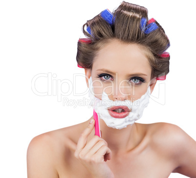 Delightful model in hair curlers posing with razor